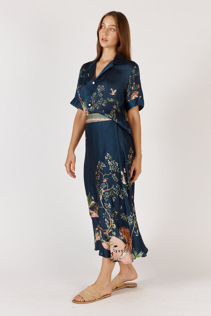 Side view of RubyYaya Machali A-line midi skirt Navy in viscose satin, highlighting drape and flattering silhouette.